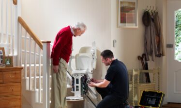 Stannah technician performing maintenance on a Stannah stairlift.