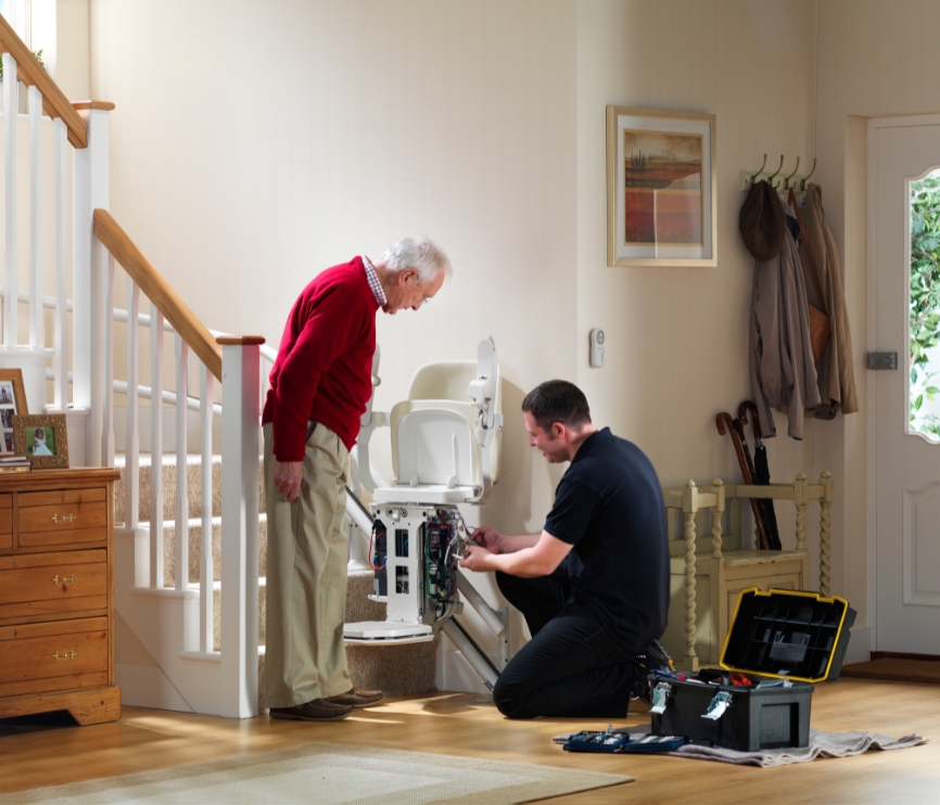 Stannah technician performing maintenance on a Stannah stairlift.